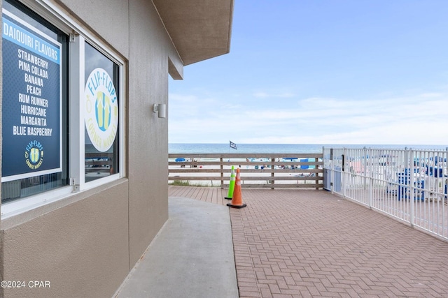 view of patio with a water view and a balcony