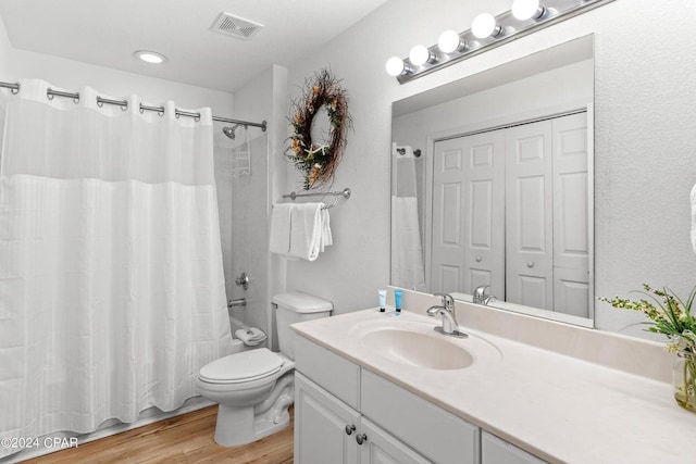 full bathroom featuring hardwood / wood-style flooring, vanity, toilet, and shower / bathtub combination with curtain