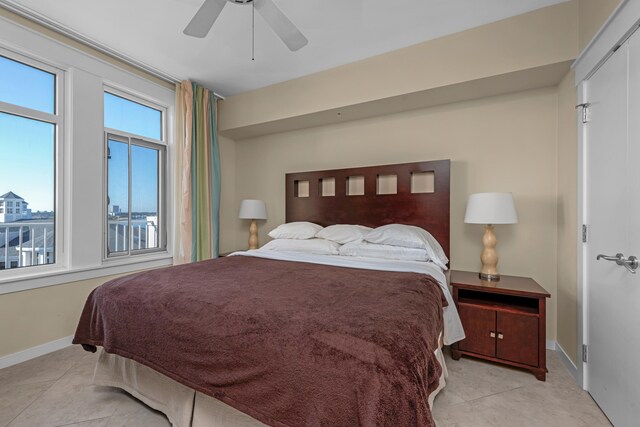 tiled bedroom featuring ceiling fan