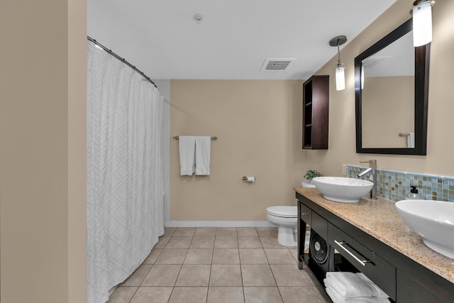 bathroom with tile flooring, toilet, and dual vanity