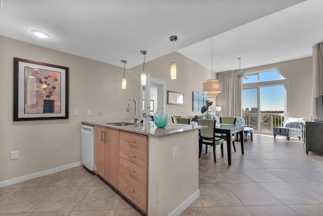 kitchen with light tile flooring, decorative light fixtures, sink, and light stone counters