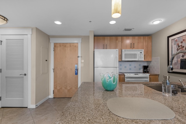 kitchen featuring light stone counters, white appliances, backsplash, light tile floors, and sink