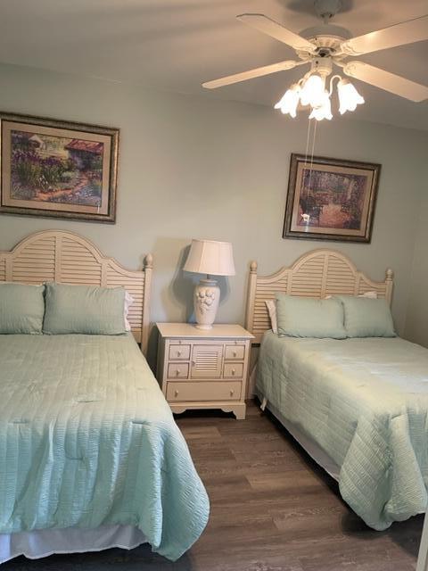 bedroom with dark hardwood / wood-style flooring and ceiling fan