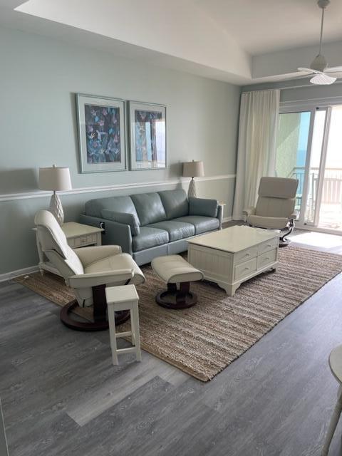 living room featuring hardwood / wood-style floors and ceiling fan