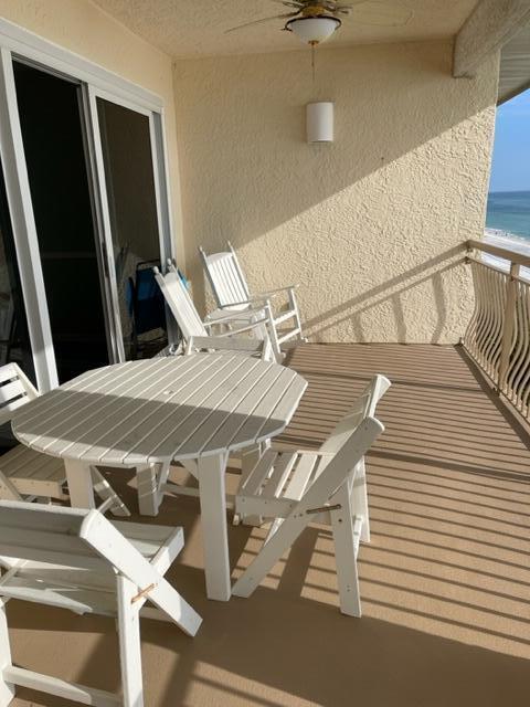 balcony with ceiling fan and a water view