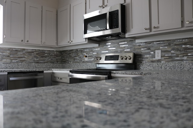 106 Star Dr Unit A, B, C, Fort Walton Beach, FL 32547 - kitchen featuring backsplash, appliances with stainless steel finishes, white cabinetry, and light stone countertops