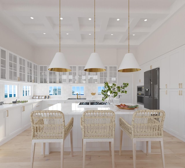 kitchen featuring a center island, coffered ceiling, stainless steel appliances, and hanging light fixtures