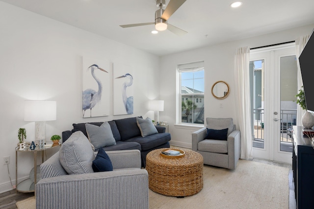 living room with light hardwood / wood-style floors, ceiling fan, and french doors