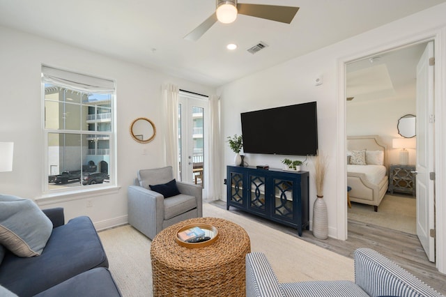 living room with light hardwood / wood-style floors and ceiling fan