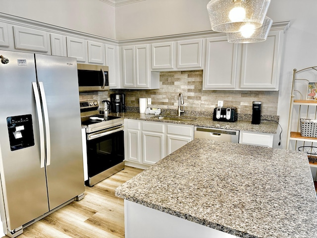 kitchen with backsplash, appliances with stainless steel finishes, light hardwood / wood-style floors, and sink