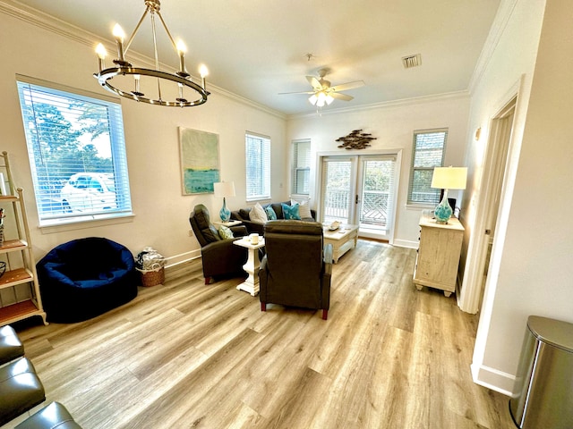 living room featuring french doors, ceiling fan with notable chandelier, light wood-type flooring, and crown molding