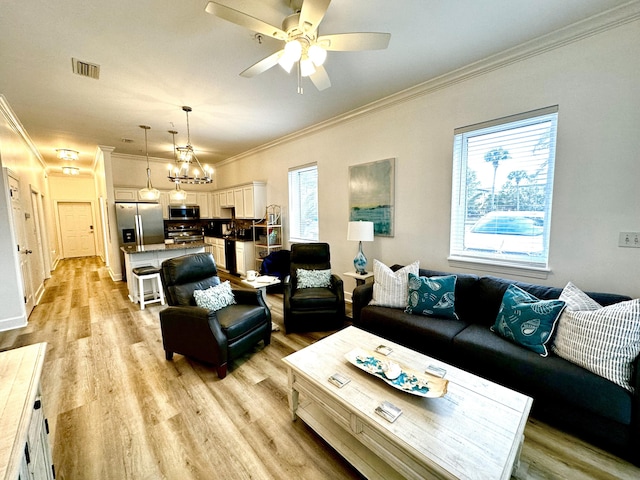 living room featuring ceiling fan with notable chandelier, ornamental molding, and light hardwood / wood-style flooring