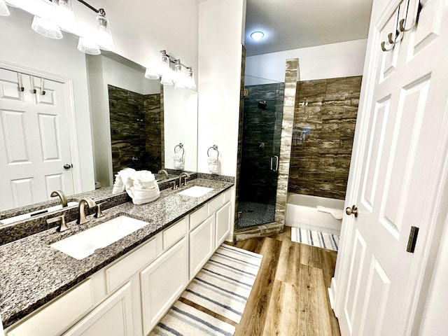 bathroom featuring hardwood / wood-style floors, an enclosed shower, and dual vanity