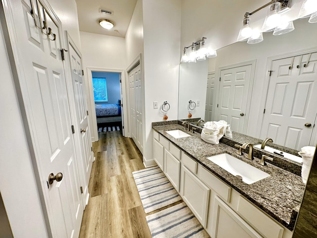 bathroom featuring dual sinks, wood-type flooring, and oversized vanity