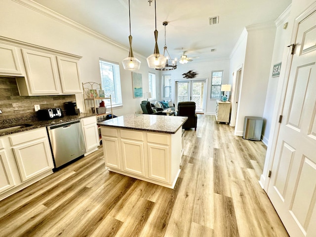 kitchen with a kitchen island, light hardwood / wood-style floors, backsplash, dishwasher, and ceiling fan with notable chandelier