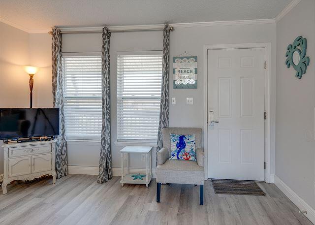 sitting room with ornamental molding and light hardwood / wood-style flooring