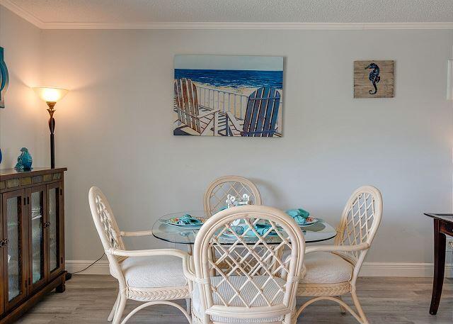 dining space featuring ornamental molding, light hardwood / wood-style flooring, and a textured ceiling