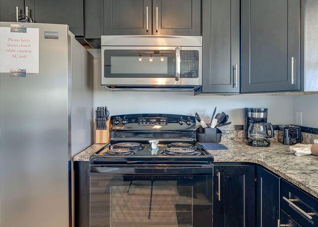 kitchen featuring stainless steel appliances and light stone countertops