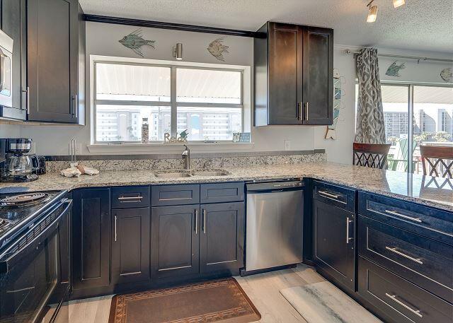 kitchen featuring light hardwood / wood-style flooring, dishwasher, a textured ceiling, and light stone counters