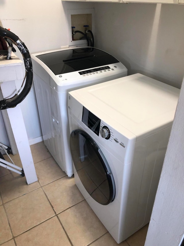 clothes washing area featuring independent washer and dryer, hookup for a washing machine, and light tile floors