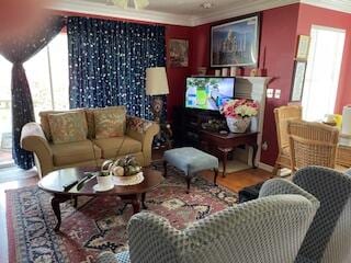 living room with ornamental molding, wood-type flooring, and plenty of natural light