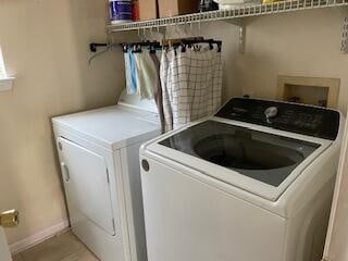 washroom featuring washer hookup, washing machine and dryer, and light tile floors