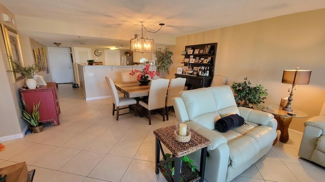 dining area featuring light tile patterned floors, a textured ceiling, baseboards, and a notable chandelier