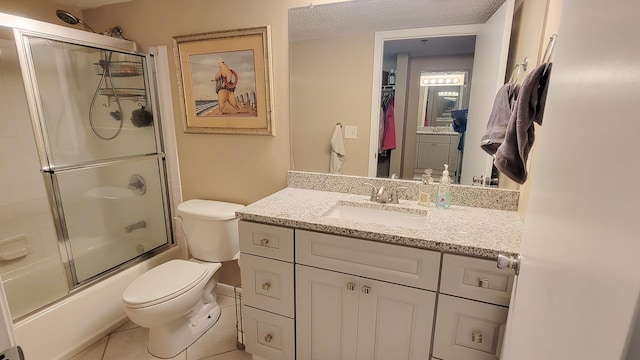 full bath featuring bath / shower combo with glass door, toilet, a textured ceiling, vanity, and tile patterned floors