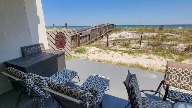 view of patio featuring a water view and fence