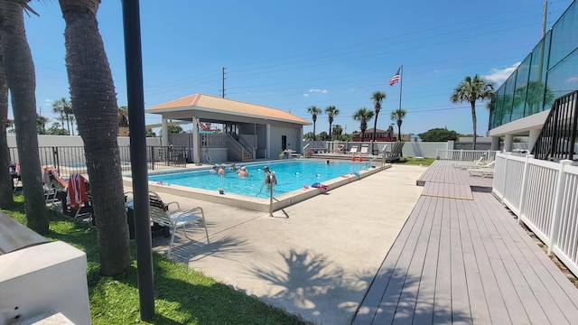 pool with a patio area and fence