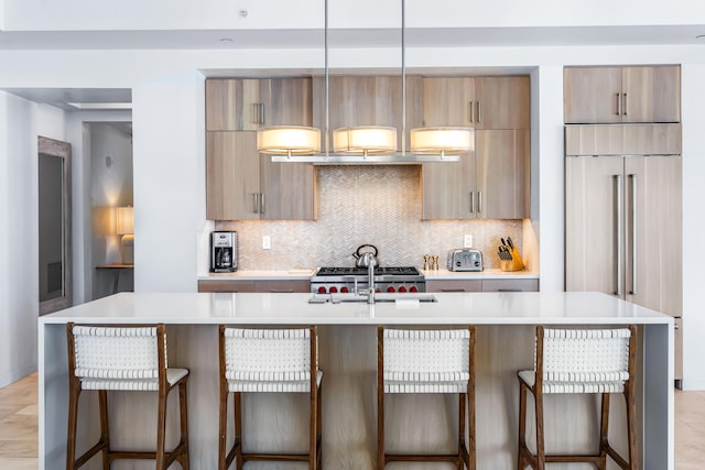 kitchen with decorative light fixtures, an island with sink, and a kitchen breakfast bar