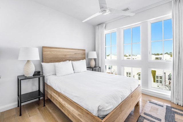 bedroom with light hardwood / wood-style flooring and ceiling fan