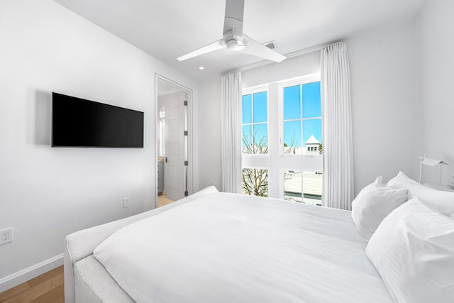 bedroom with light hardwood / wood-style floors, ceiling fan, and multiple windows