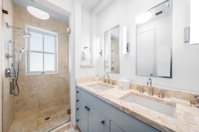 bathroom featuring double vanity and a tile shower