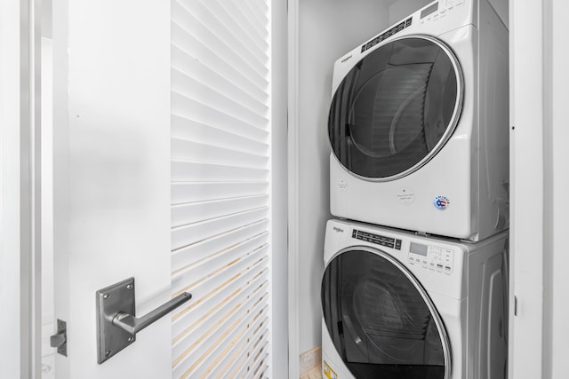 clothes washing area featuring stacked washer and clothes dryer