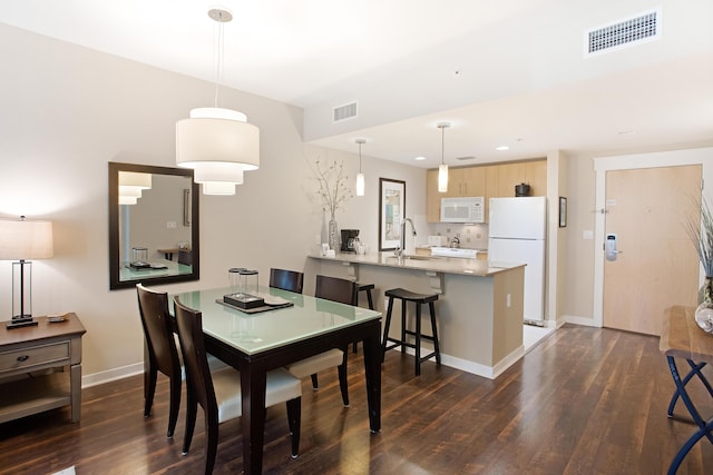 dining area with dark hardwood / wood-style floors and sink