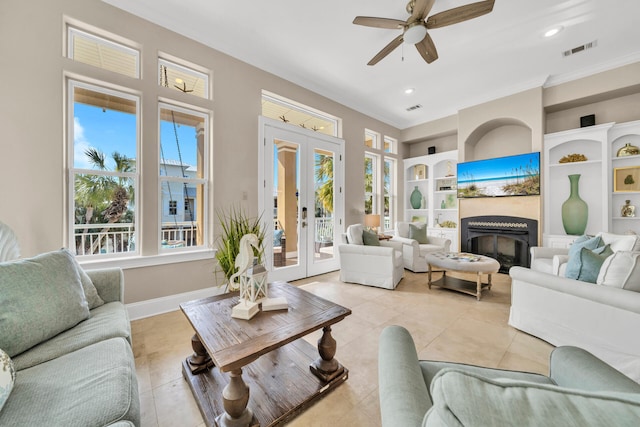 living room featuring french doors, ornamental molding, built in shelves, ceiling fan, and light tile patterned floors