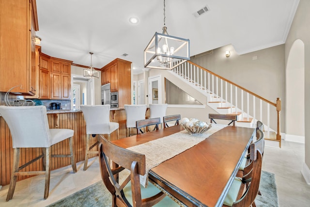 dining space with crown molding and an inviting chandelier