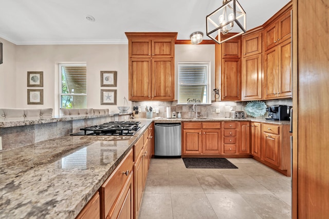 kitchen featuring dishwasher, gas cooktop, light stone counters, a notable chandelier, and decorative light fixtures