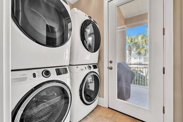 clothes washing area featuring light tile patterned floors and stacked washer and clothes dryer