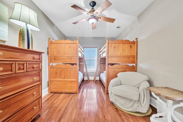 bedroom featuring ceiling fan, light wood-type flooring, and vaulted ceiling