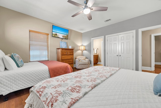 bedroom featuring hardwood / wood-style floors, ceiling fan, ensuite bathroom, and a closet