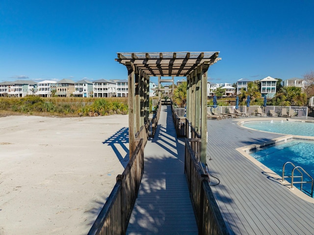 dock area featuring a pergola and a community pool