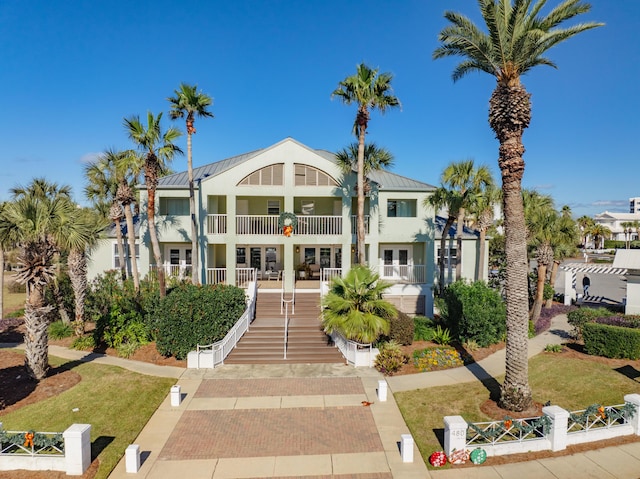 view of front of property featuring a front yard and a balcony