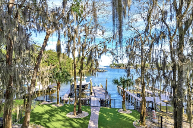 dock area featuring a water view and a lawn