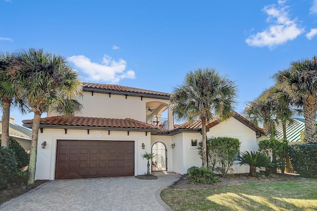 mediterranean / spanish home with a balcony, a garage, and a front yard