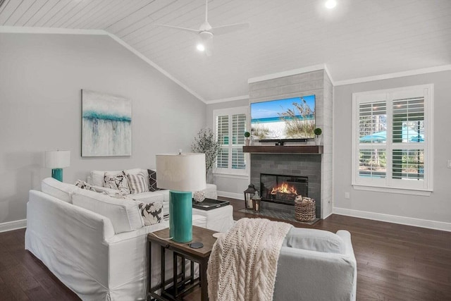 living room featuring ceiling fan, a fireplace, dark hardwood / wood-style flooring, ornamental molding, and vaulted ceiling