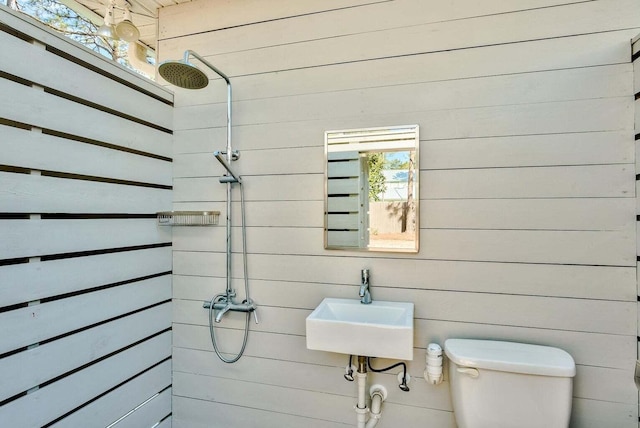 bathroom with a shower, toilet, and sink