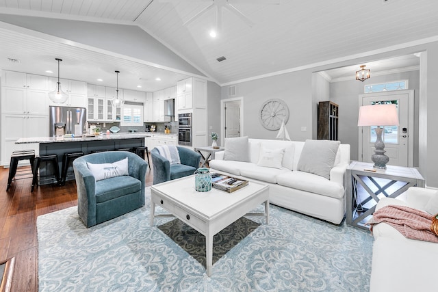 living room with ornamental molding, wood-type flooring, vaulted ceiling, and an inviting chandelier