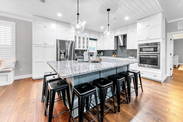 kitchen featuring appliances with stainless steel finishes, light wood-type flooring, and white cabinetry